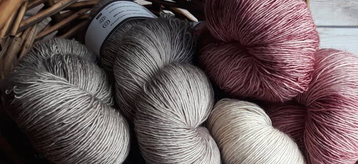 A collection of colorful yarn skeins in a basket, perfect for knitting and crafting projects.